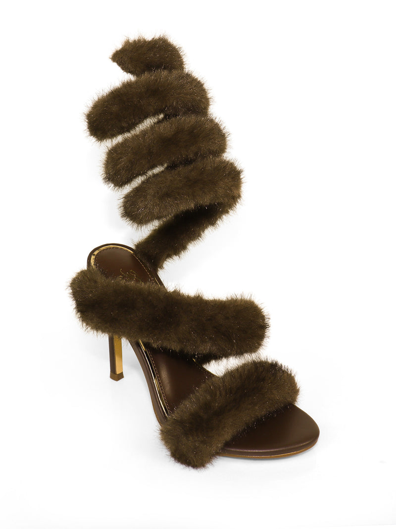 The Allure Fluffy Stiletto Sandal by Frederick's of Hollywood features thick, fuzzy brown straps spiraling from toe to above the ankle atop a brown sole and heel—a bold statement heel showcased against a white background.