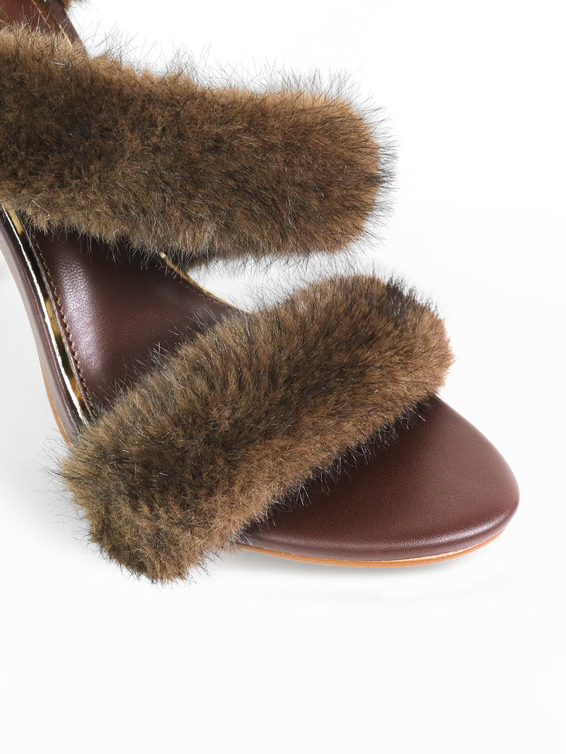 The Allure Fluffy Stiletto Sandal from Frederick's of Hollywood features two plush faux fur straps and a brown open-toe design, creating a glamorous silhouette and bold statement, shown against a white background.