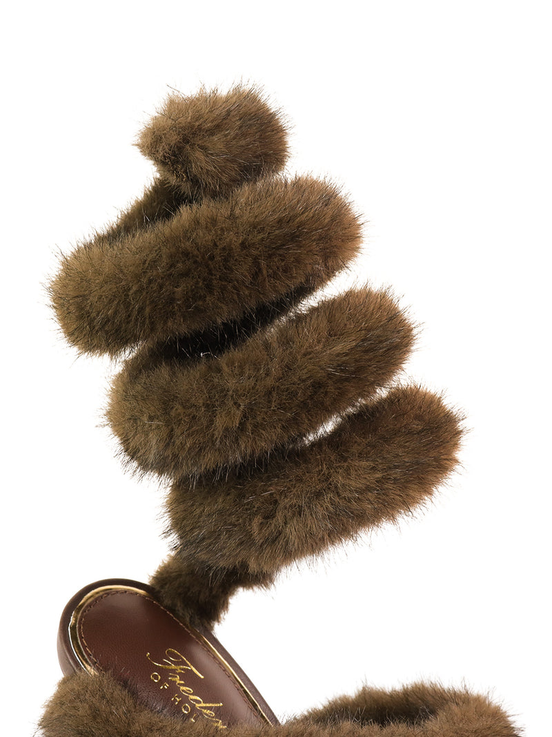 The Allure Fluffy Stiletto Sandal by Frederick's of Hollywood features a brown spiral-shaped strap covered in soft, fluffy fur, highlighting its glamorous silhouette and statement style against a white background.