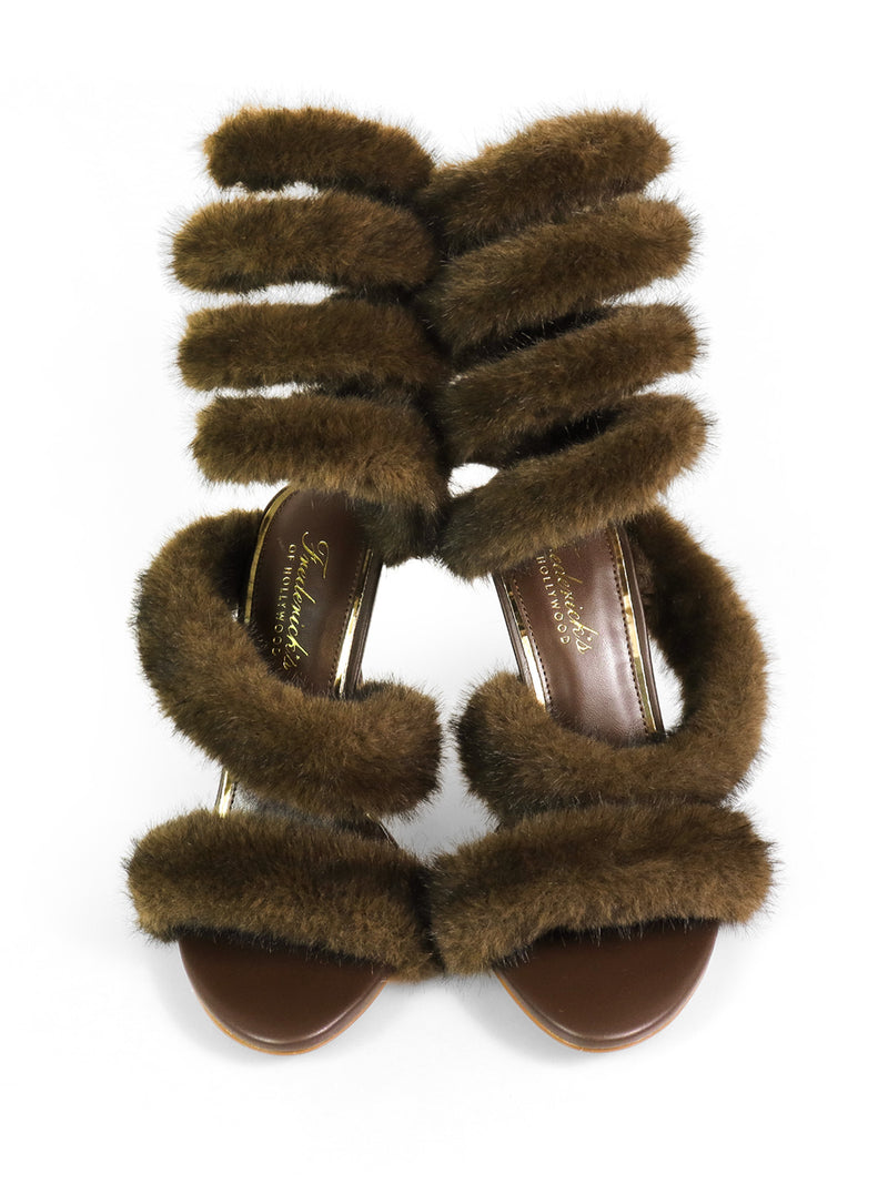 The Allure Fluffy Stiletto Sandal by Frederick's of Hollywood features brown high heels with wide, plush fur straps across the foot and ankle for a glamorous look, shown against a white background.