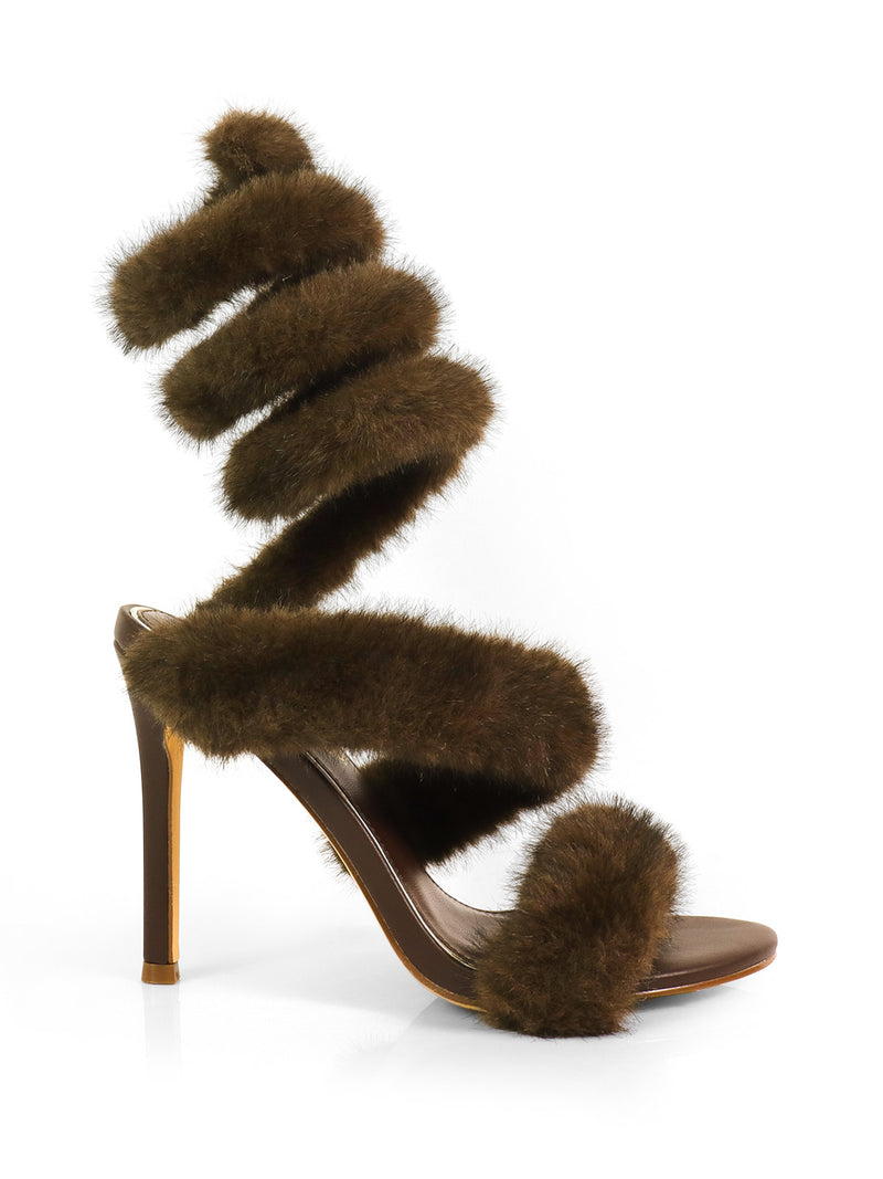 The Allure Fluffy Stiletto Sandal by Frederick's of Hollywood features brown faux fur straps and a long, spiral wrap that creates a glamorous statement against a plain white background.