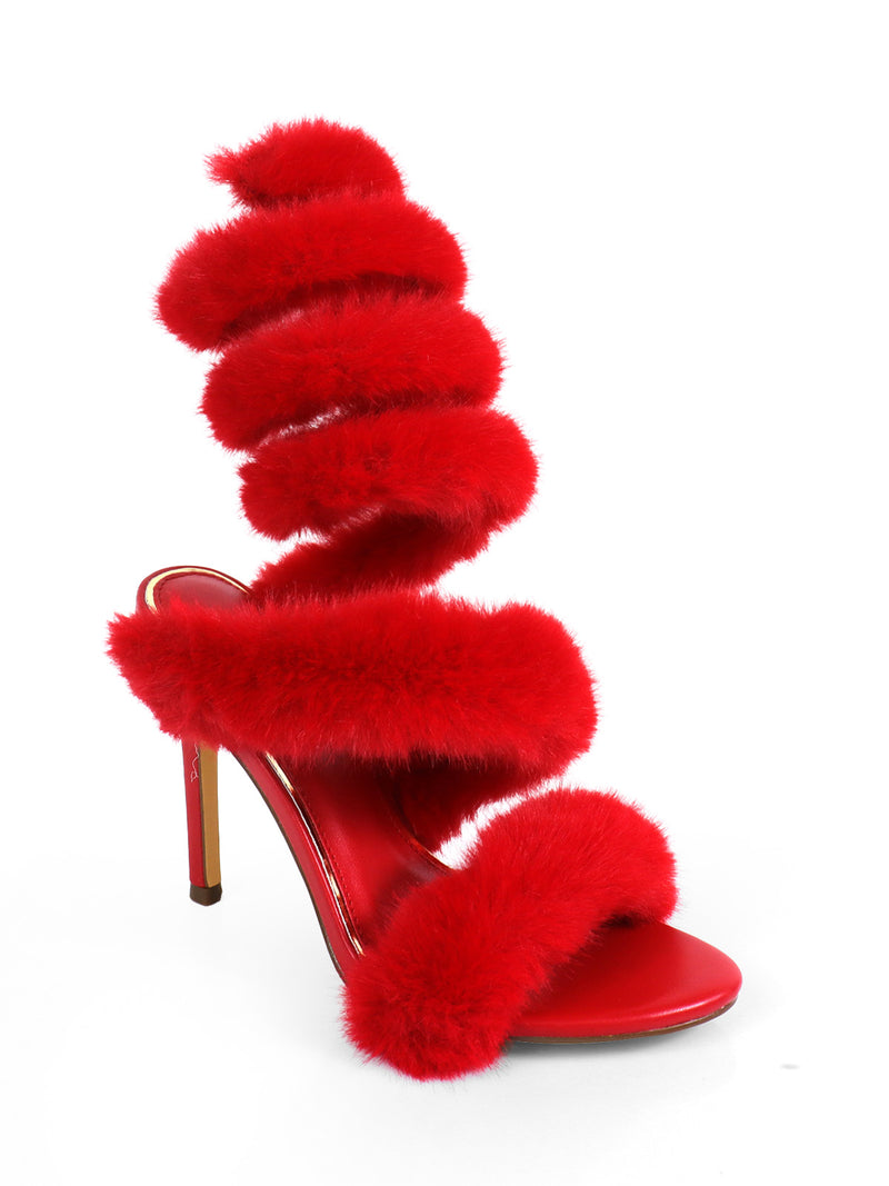 The Allure Fluffy Stiletto Sandal by Frederick's of Hollywood features three thick, bright red fluffy straps and an elaborate spiral of matching fluff up the ankle—perfect statement heels against a crisp white backdrop.