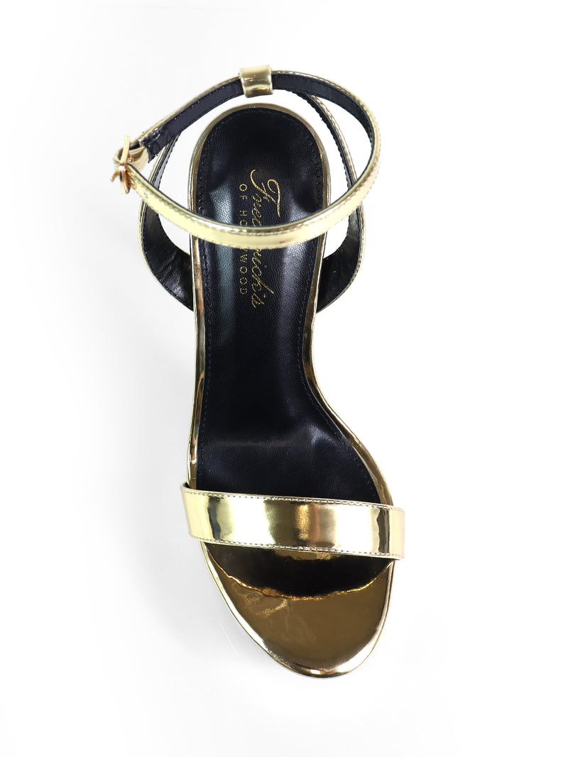 A single Cupid Strap Platform Heel by Frederick's of Hollywood, featuring shiny gold toe and ankle straps and a black insole with gold branding, displayed top-down on a white background.
