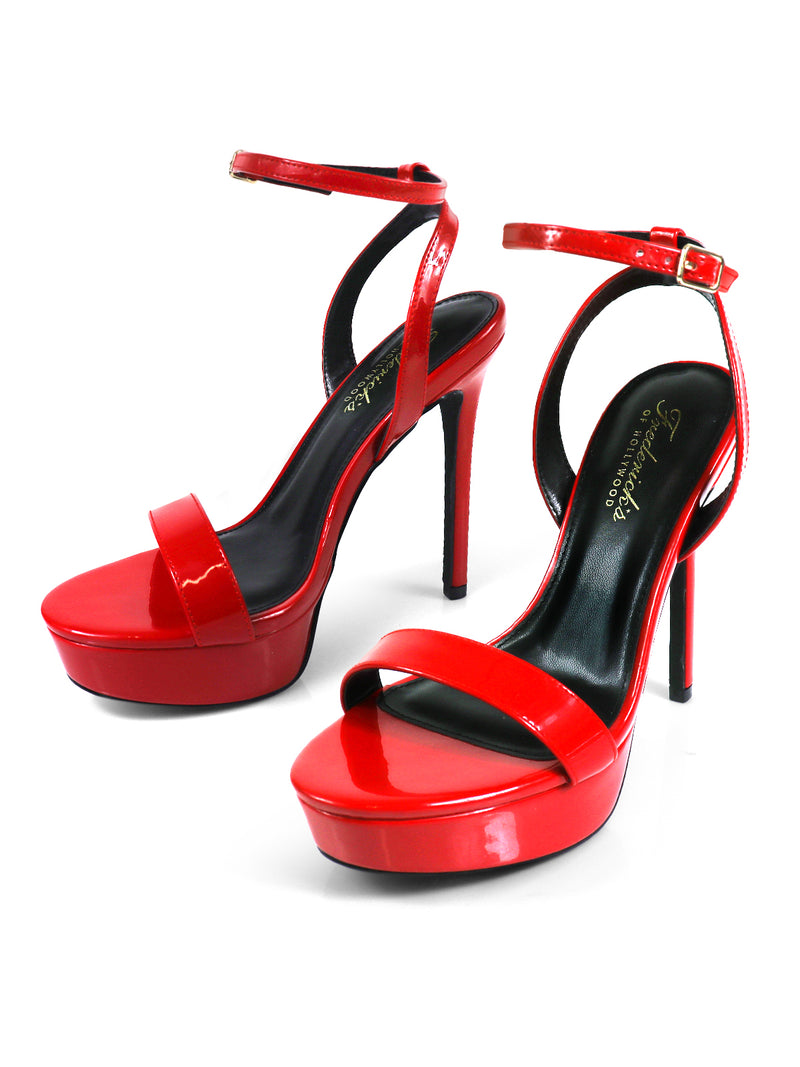 The Cupid Strap Platform Heels by Frederick's of Hollywood are shiny red high-heeled sandals with ankle straps, open toes, and bold platform heels, shown on a white background.