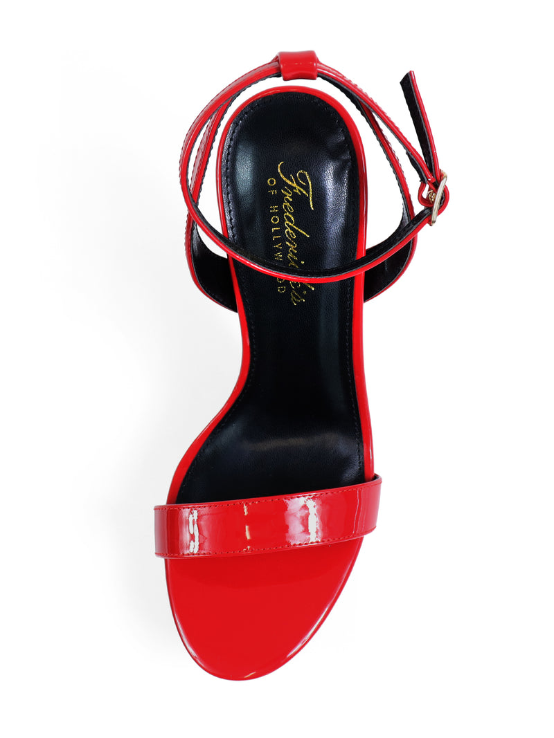 The Cupid Strap Platform Heels by Frederick’s of Hollywood are shiny red high-heeled sandals with elegant strap details, including a single front strap, ankle strap with gold buckle, and a branded black insole.