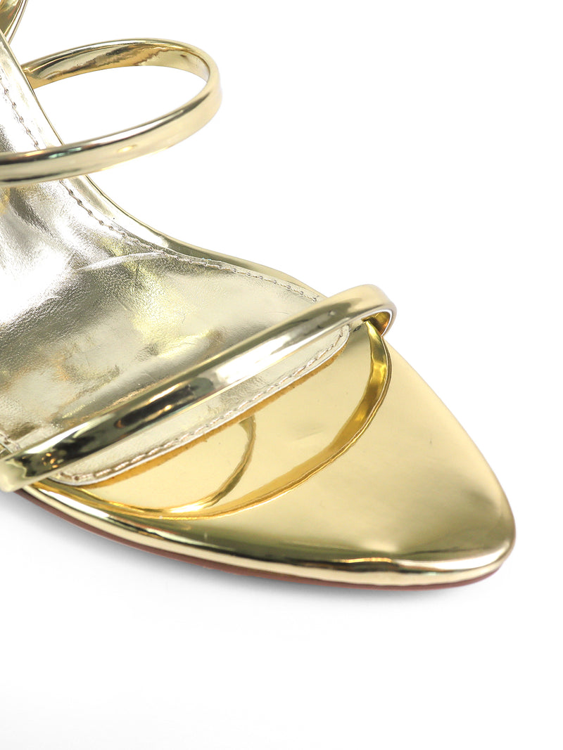 Close-up of the Cynthia Pointy Toe Pencil Heel by Frederick's of Hollywood—a gold high-heeled sandal with two slim front straps and an open toe, showcased against a white background.