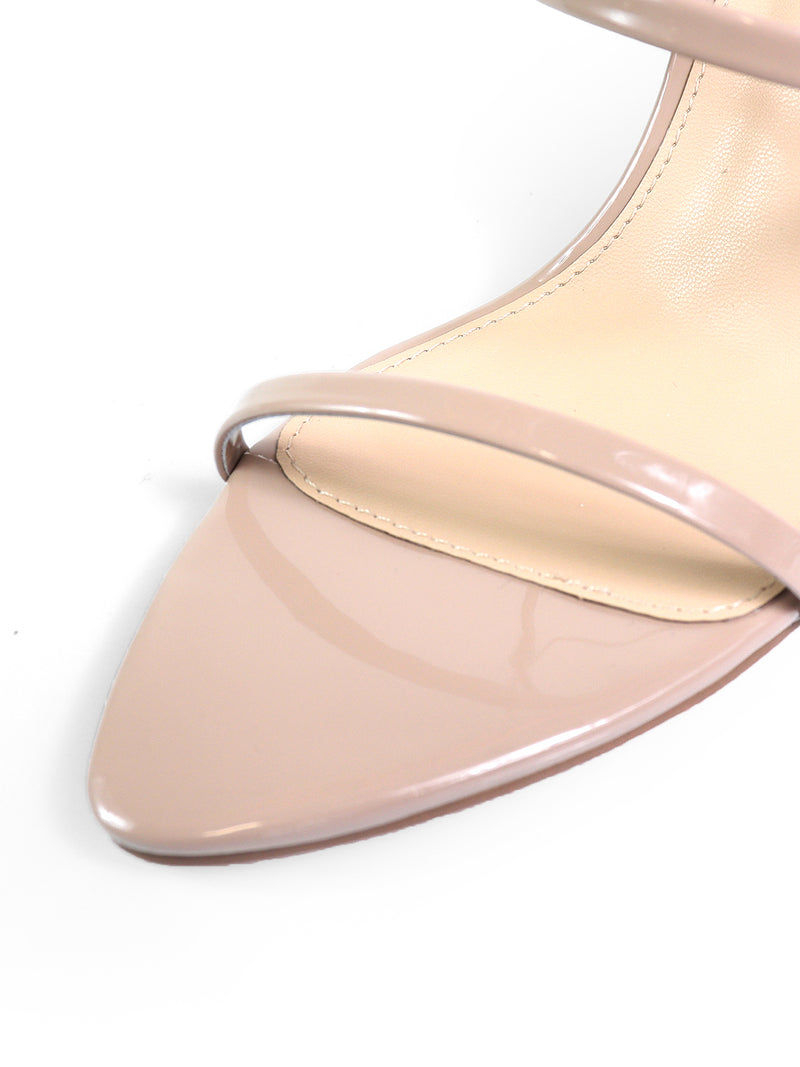 Close-up of the Cynthia Pointy Toe Pencil Heel by Frederick's of Hollywood—a nude patent leather sandal featuring two thin toe straps, a pointed toe, and a pencil heel, displayed on a white background.