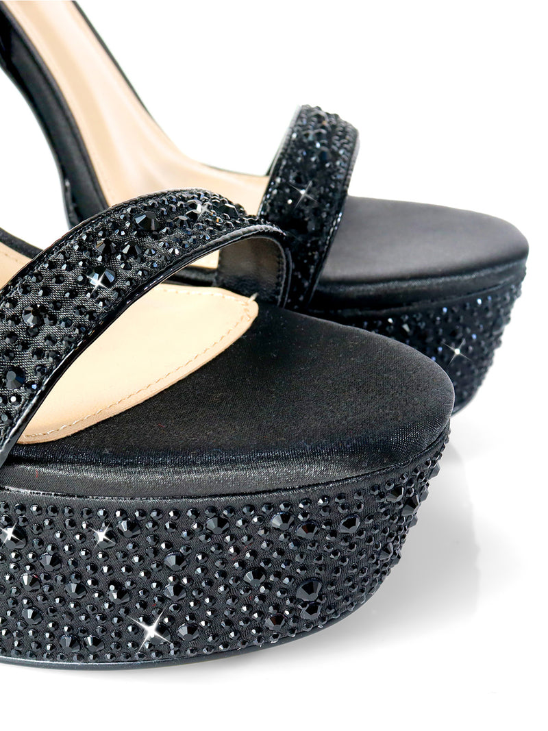 Close-up of Frederick's of Hollywood Fabiosa Rhinestone Open Toe Platform Heel—black sandals with sparkling rhinestone accents on straps and soles, ideal for evening wear—set against a white background.