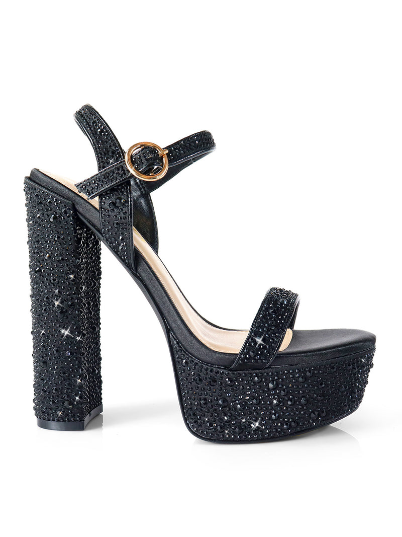 The Fabiosa Rhinestone Open Toe Platform Heel by Frederick's of Hollywood features black straps, an ankle buckle, sparkling rhinestone details, and a chunky high heel—ideal for glamorous evening occasions.