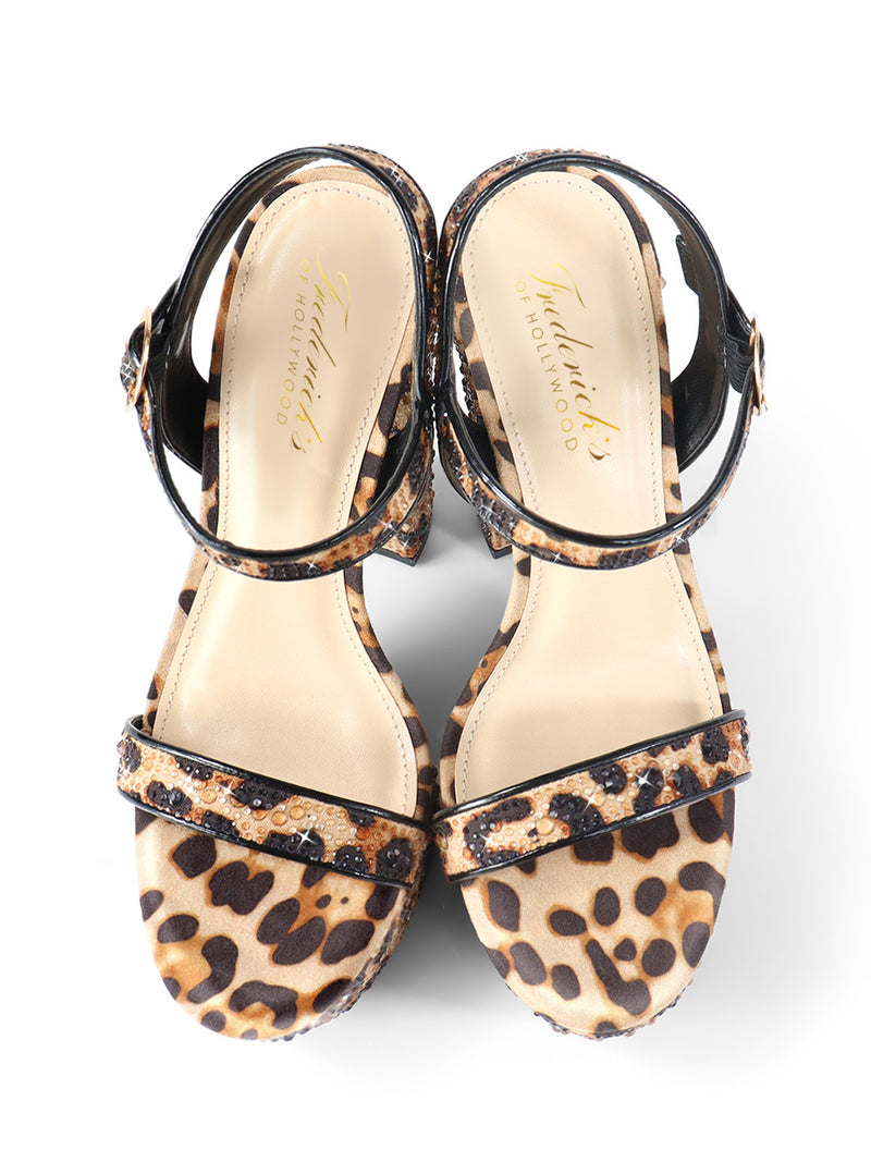 The Fabiosa Rhinestone Open Toe Platform Heel by Frederick's of Hollywood features leopard print, ankle straps, and beige insoles—perfect for evening wear. The women’s sandals are shown side by side on a white background.