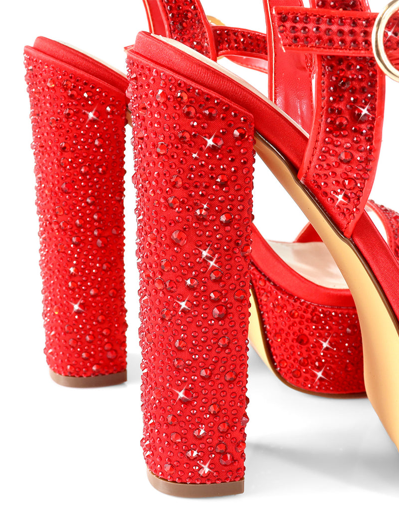 Close-up of Frederick's of Hollywood Fabiosa Rhinestone Open Toe Platform Heel, featuring sparkling red rhinestones, gold accents, and a beige sole. Perfect evening wear heels dazzled in red against a white background.