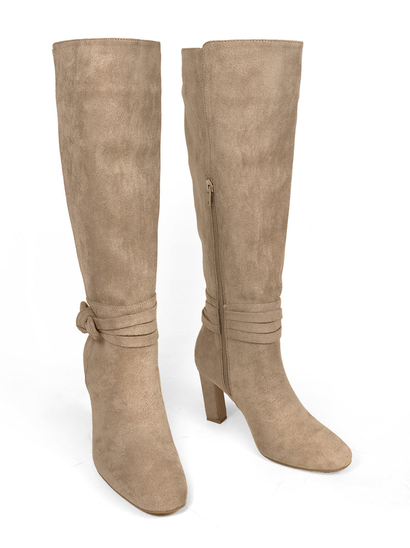 The Janeth Ankle Heel Boots by Frederick's of Hollywood are beige suede boots featuring a mid-height chunky heel, side zipper, and decorative ankle straps with a stylish knot detail, displayed on a white background.