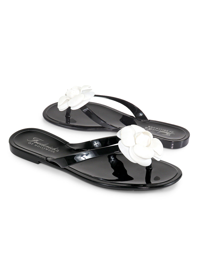 Frederick's of Hollywood Jelli Camellia Thong Sandals feature glossy black straps adorned with white flower accents‚Äîa stylish, feminine choice for warm-weather wear.