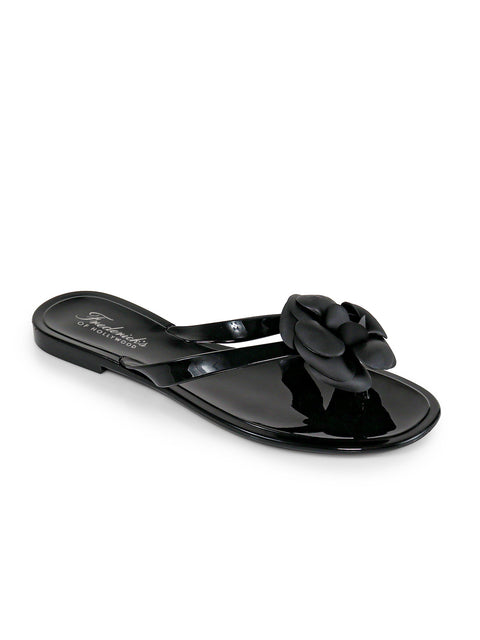 The Jelli Camellia Thong Sandals by Frederick's of Hollywood feature a black, glossy finish with a large camellia flower on the upper, shiny sole, and white brand name‚Äîperfect for chic warm-weather looks.