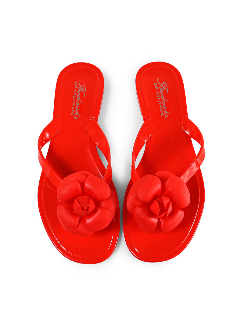 A pair of shiny red Jelli Camellia Thong Sandals by Frederick's of Hollywood, featuring large camellia-inspired strap details, shown from above on a white background.