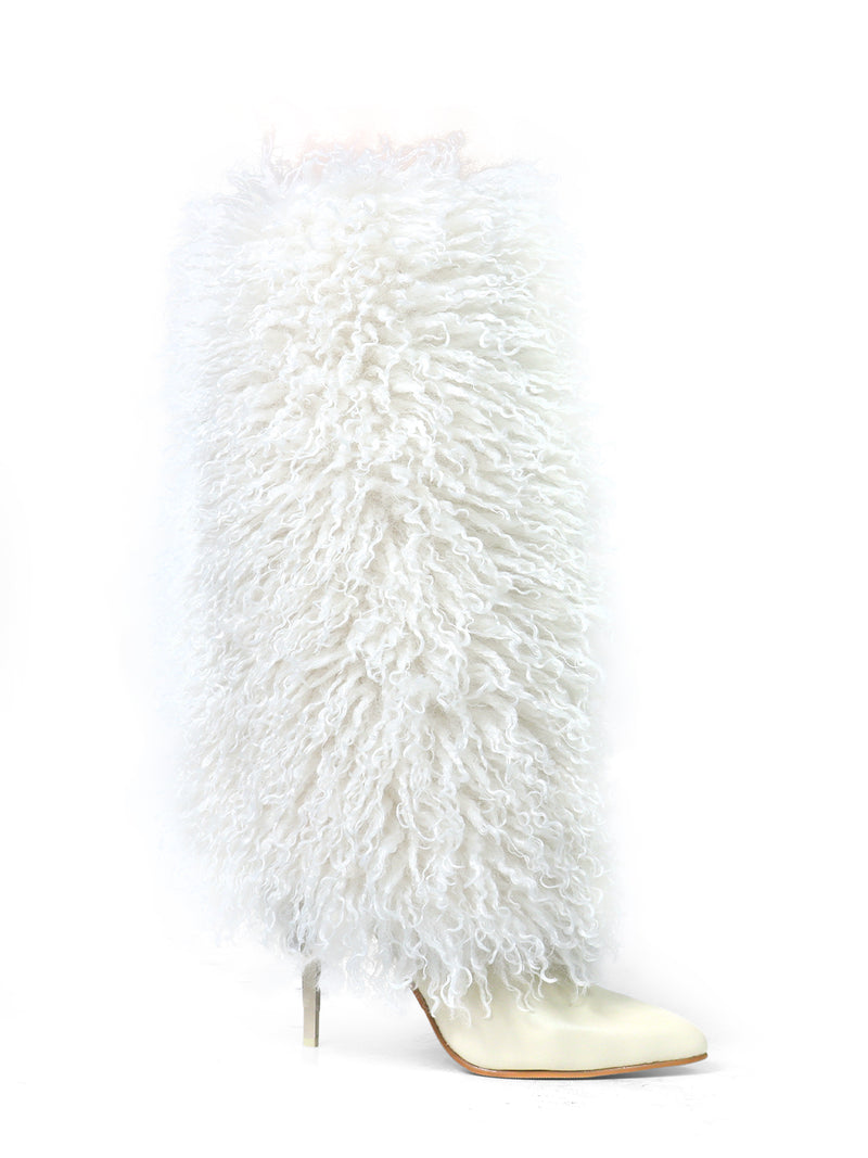 The Kiki Pointed Toe Fluffy Boot by Frederick's of Hollywood is a knee-high white boot with a stiletto heel and pointed toe, covered in long, curly faux fur for a bold, fashion-forward statement.