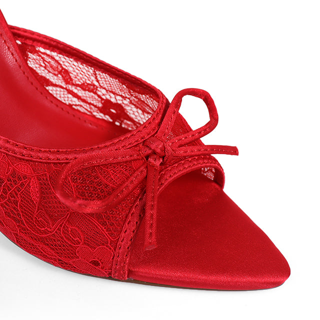Close-up of Frederick's of Hollywood Lacey Pointed Toe Lace Bow Heels featuring red lace detailing, an elegant front bow, and a matching red inner lining with a delicate lace pattern.