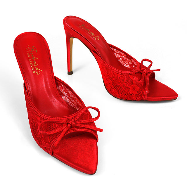 The Lacey Pointed Toe Lace Bow Heels by Frederick's of Hollywood feature elegant red lace, a chic front bow, and branded gold-letter insoles for a touch of luxury.