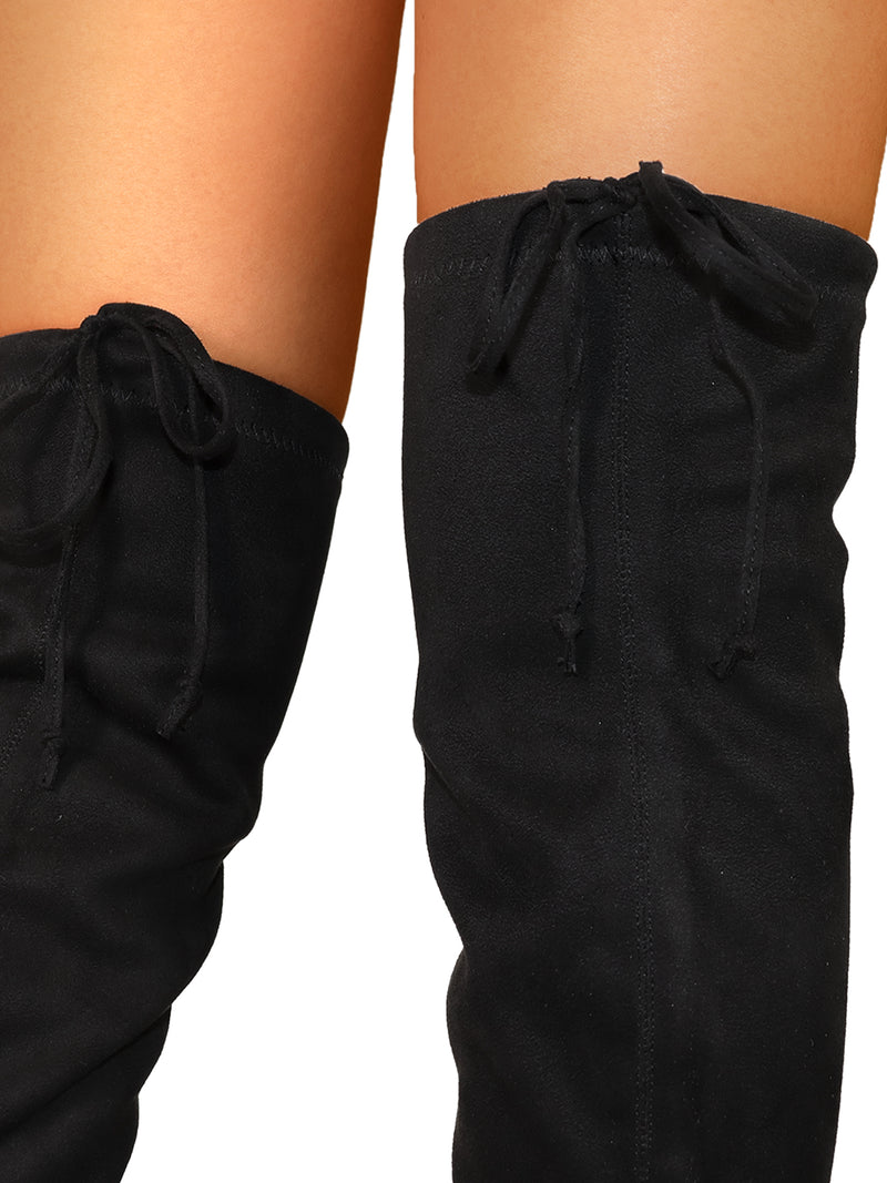 Close-up of a person wearing Frederick's of Hollywood Letizia Thigh High Super Stretch Boots in black, featuring drawstring ties at the top and baring skin above for a true statement-making style.