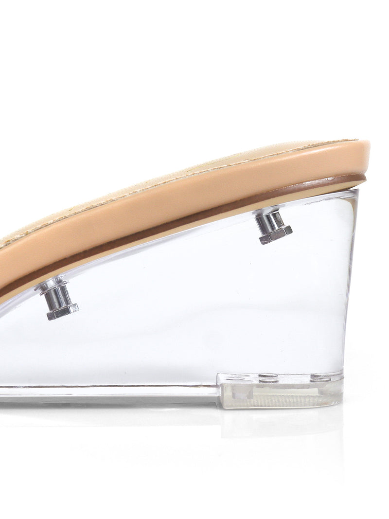 Close-up side view of Frederick's of Hollywood Lora Transparent Mule Wedges, showcasing clear wedge heels, beige insoles, and prominent metal screws—a bold pick for minimalist shoe lovers.