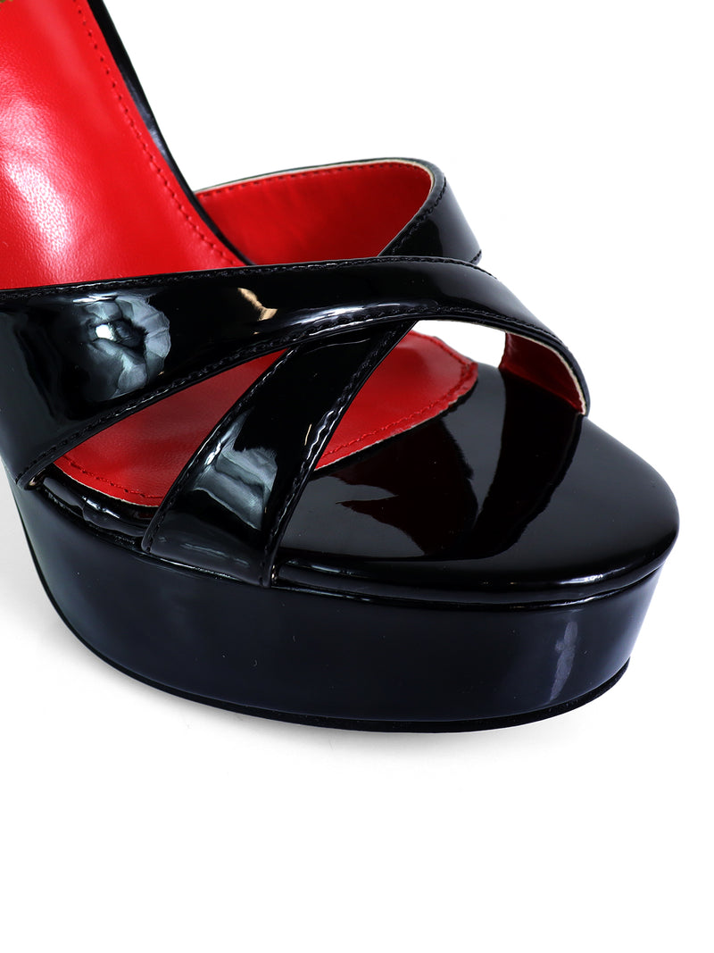 Close-up of Madison Ankle Strap Heels by Frederick's of Hollywood, featuring glossy black patent leather straps, a thick platform sole, and a bold red interior lining—ideal for elevating your evening look.