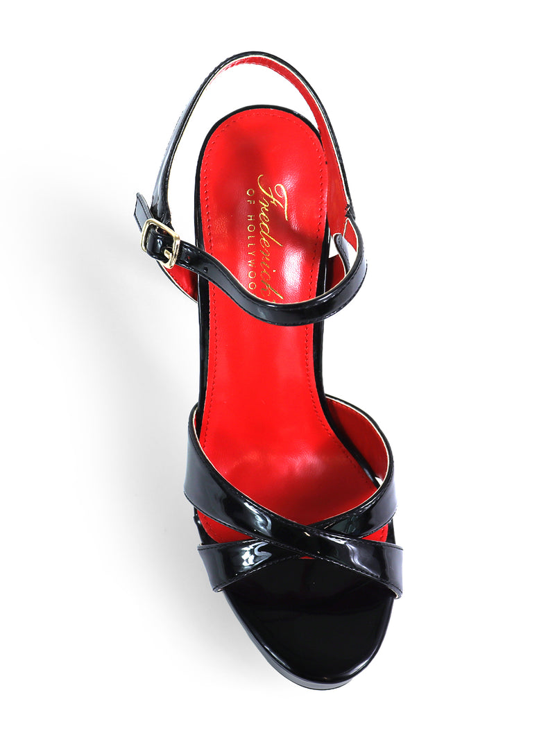 The Madison Ankle Strap Heels by Frederick's of Hollywood feature black patent leather, crisscross straps with a gold buckle, and a bold red insole. Shown from above, these elegant heels stand out against a white background.