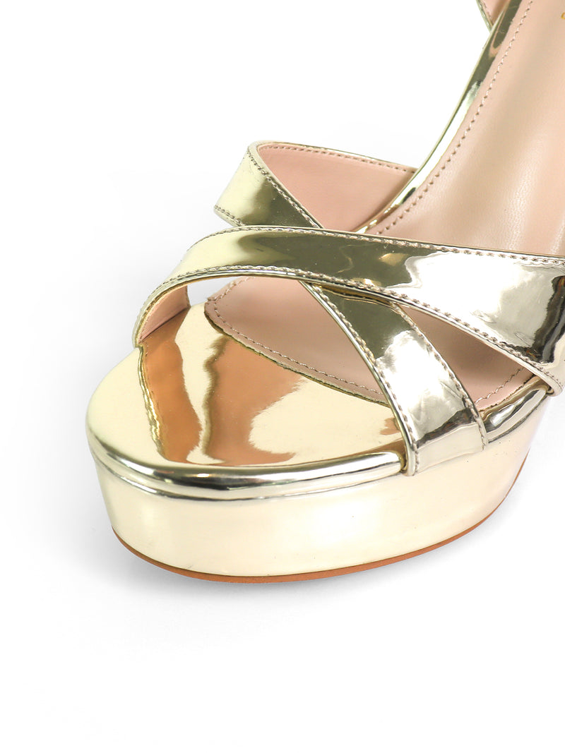 Close-up of Frederick's of Hollywood Madison Ankle Strap Heels: elegant gold platform sandals with crisscross straps and a nude insole, perfect for evening wear, set against a white background.