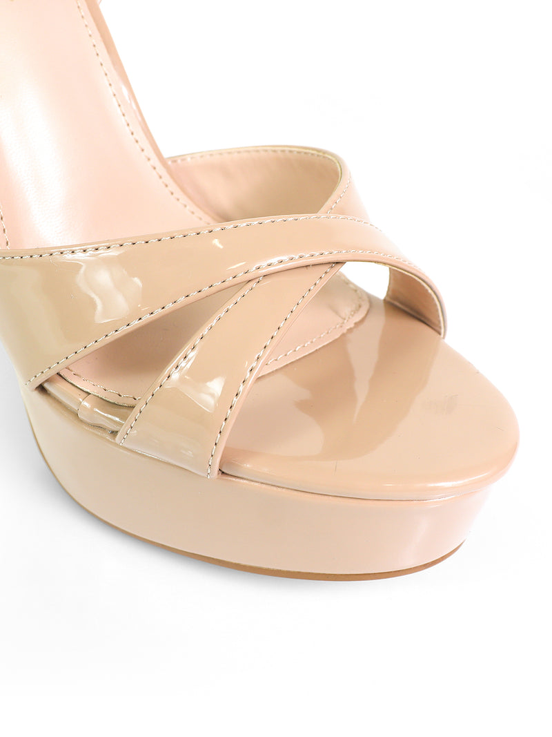 Close-up of Frederick's of Hollywood Madison Ankle Strap Heels—nude patent leather platform sandals featuring crisscross straps and an ankle strap over the open toe, set against a white background.