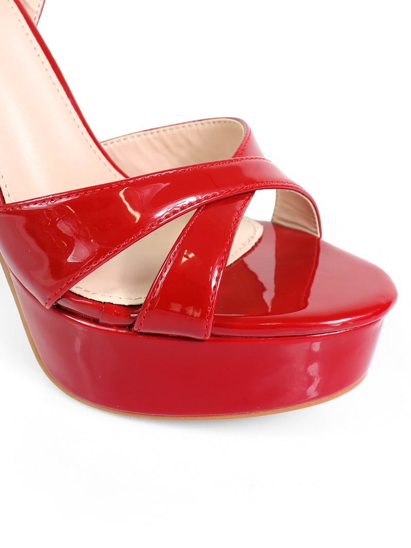 Close-up of the Madison Ankle Strap Heels by Frederick's of Hollywood, featuring shiny red crisscross straps and a beige inner lining, elegantly displayed against a white background.