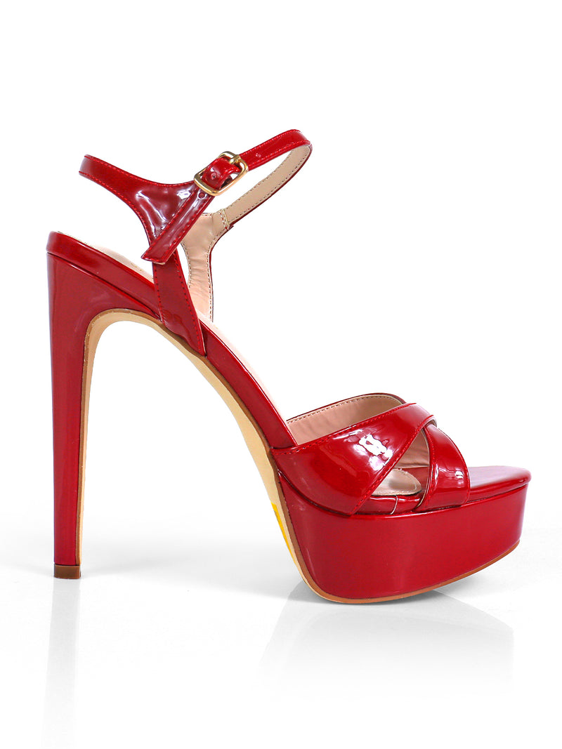 The Madison Ankle Strap Heels by Frederick's of Hollywood feature a shiny red platform, crisscross toe straps, an ankle strap with buckle, and a tall stiletto heel, elegantly displayed in a side view against a white background.