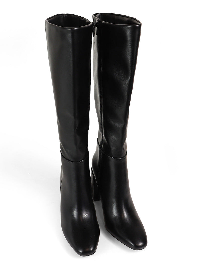 The Paola Knee High Boots by Frederick's of Hollywood feature a sleek black silhouette, low block heels, side zippers, and a smooth leather finish, shown against a white background.