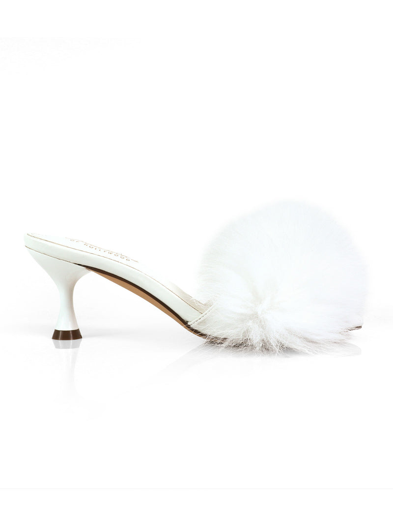 The Frederick’s of Hollywood Purr Square Toe Fur Heel is a white high-heeled slipper showcasing a chic square-toe silhouette with an open toe and topped with a large, fluffy white pom-pom on the front. Its slim heel and contemporary design create an elegant yet playful statement look.