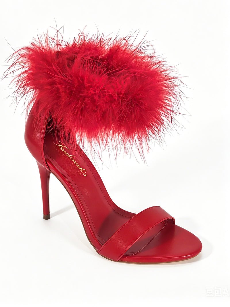 The Raquel Feather Stiletto Heel by Frederick’s of Hollywood is a striking red high-heeled sandal featuring a fluffy, feathery ankle strap and a simple toe band, elegantly showcased on a white background—an embodiment of modern luxury and timeless stiletto sophistication.
