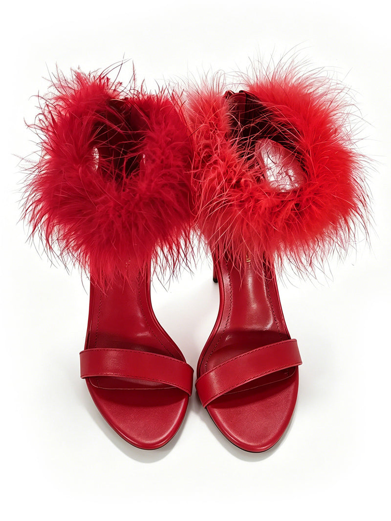 The Raquel Feather Stiletto Heel by Frederick’s of Hollywood features elegant red high-heeled sandals accented with a luxurious fluffy red feather trim around the ankle straps, embodying modern sophistication and beautifully showcased on a white background.