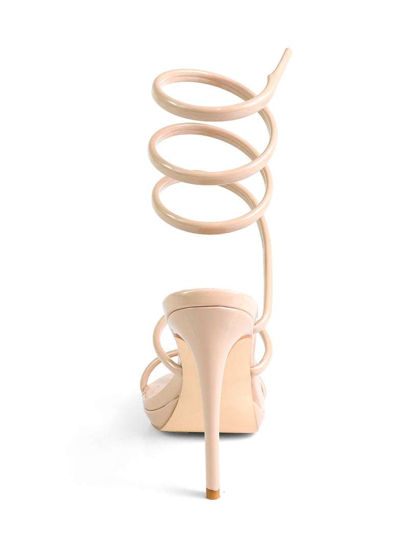 The Sabine Round Toe Heel by Frederick's of Hollywood is a nude high-heeled sandal with a spiral ankle strap that wraps upward, round toe design, and is shown from the back against a white background.
