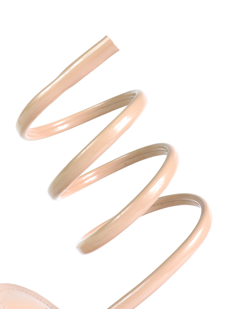 Close-up of Frederick's of Hollywood Sabine Round Toe Heel, featuring a nude, spiral-shaped strap that wraps elegantly around the ankle or leg, set against a white background.