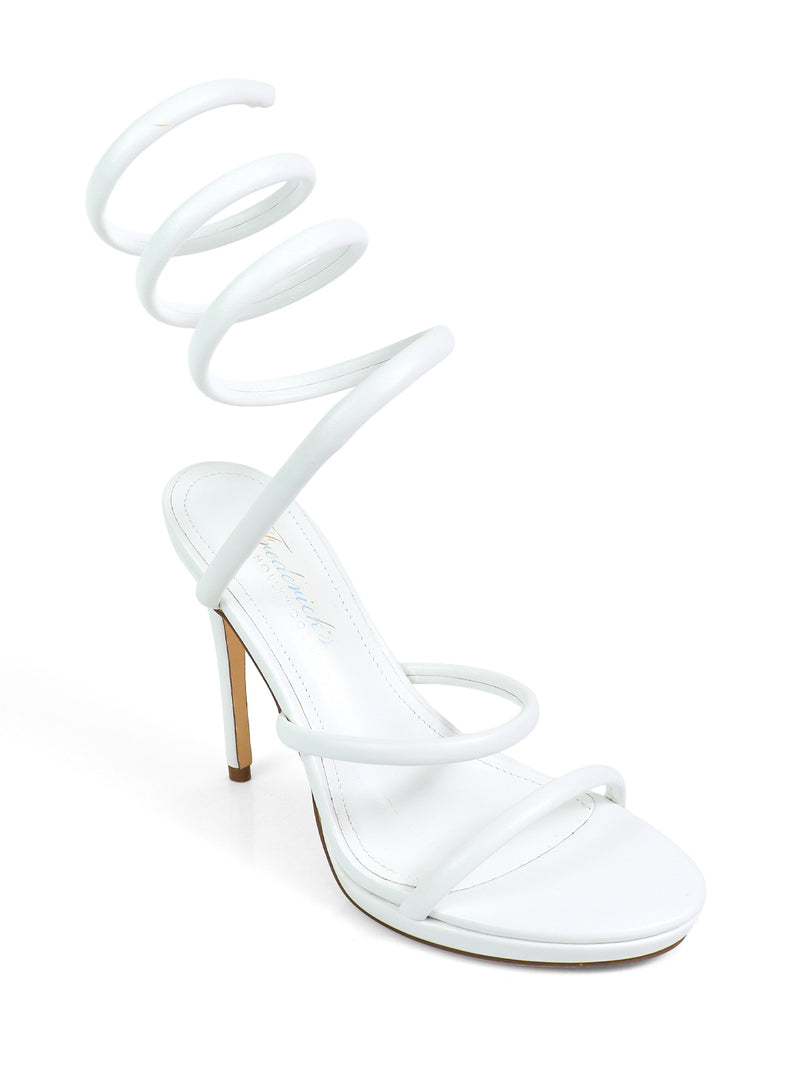 The Sabine Round Toe Heel by Frederick's of Hollywood is a white sandal with an open toe, three thin straps, and a unique spiral ankle strap—modern, sculptural heels suited for versatile styling.