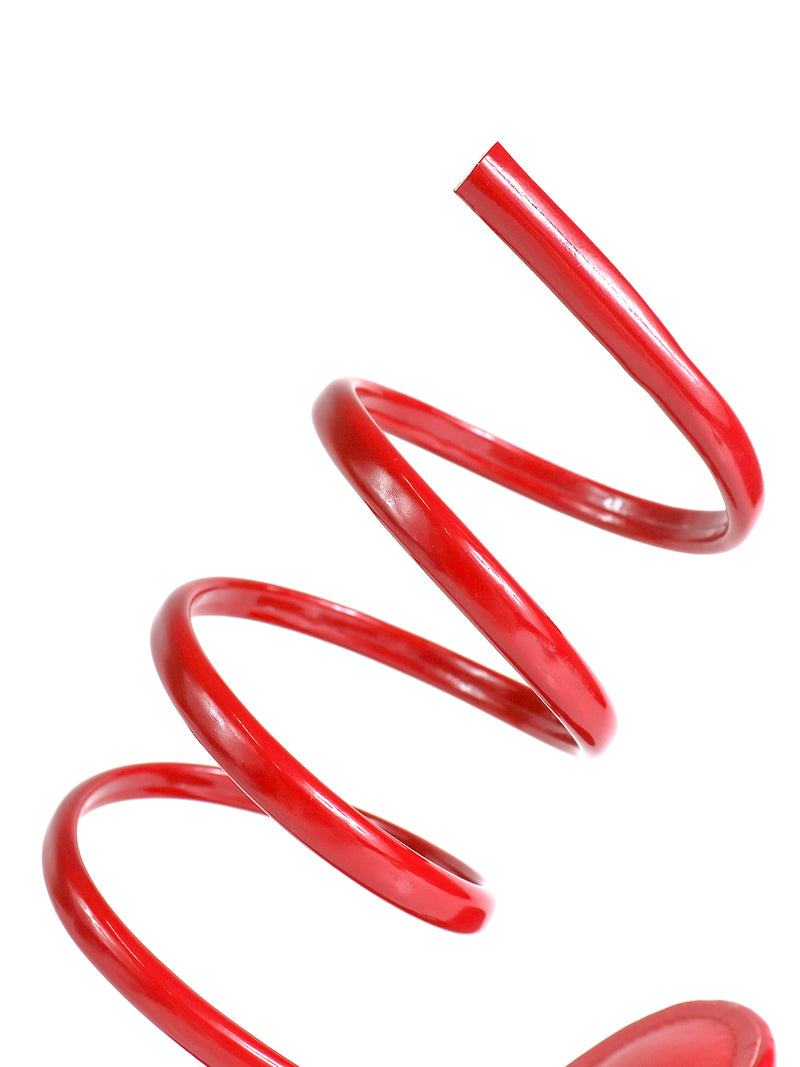 A close-up of Frederick's of Hollywood Sabine Round Toe Heel, its striking red curve set against a white background—an elegant design reminiscent of a coiled spring.