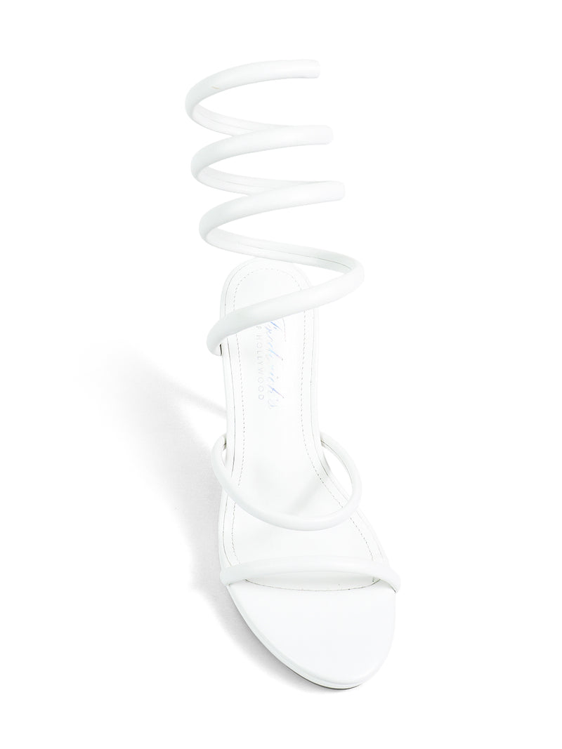 The Sabine Round Toe Heel by Frederick's of Hollywood is a white sandal with a minimalist design and spiral ankle strap, offering versatile, elegant style.