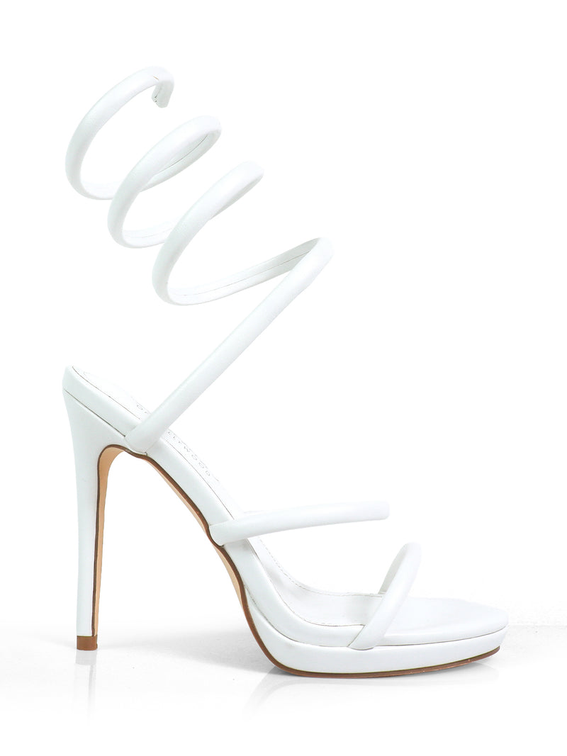 The Sabine Round Toe Heel by Frederick's of Hollywood is a white high-heeled sandal with three thin foot straps and a unique spiral ankle strap, featuring a tall slender heel and modern minimalist design perfect for versatile styling.