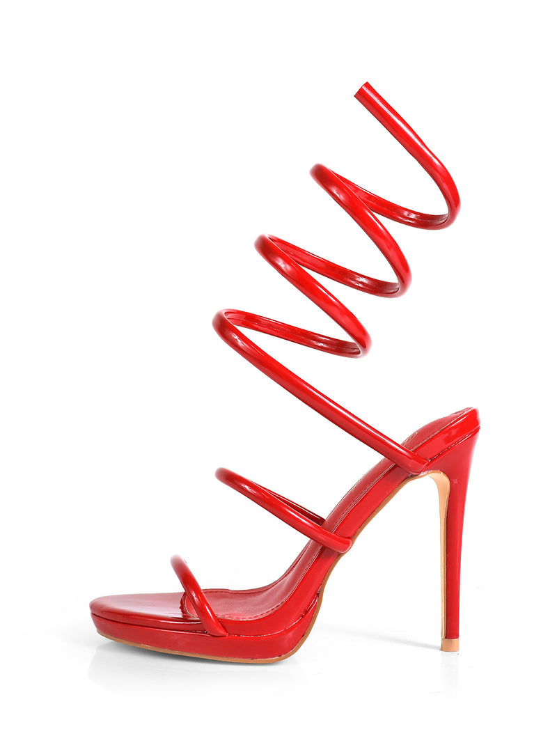 The Sabine Round Toe Heel by Frederick’s of Hollywood is a striking red sandal with an elegant spiral strap and high heel, shown on a white background—a bold, versatile choice for any occasion.