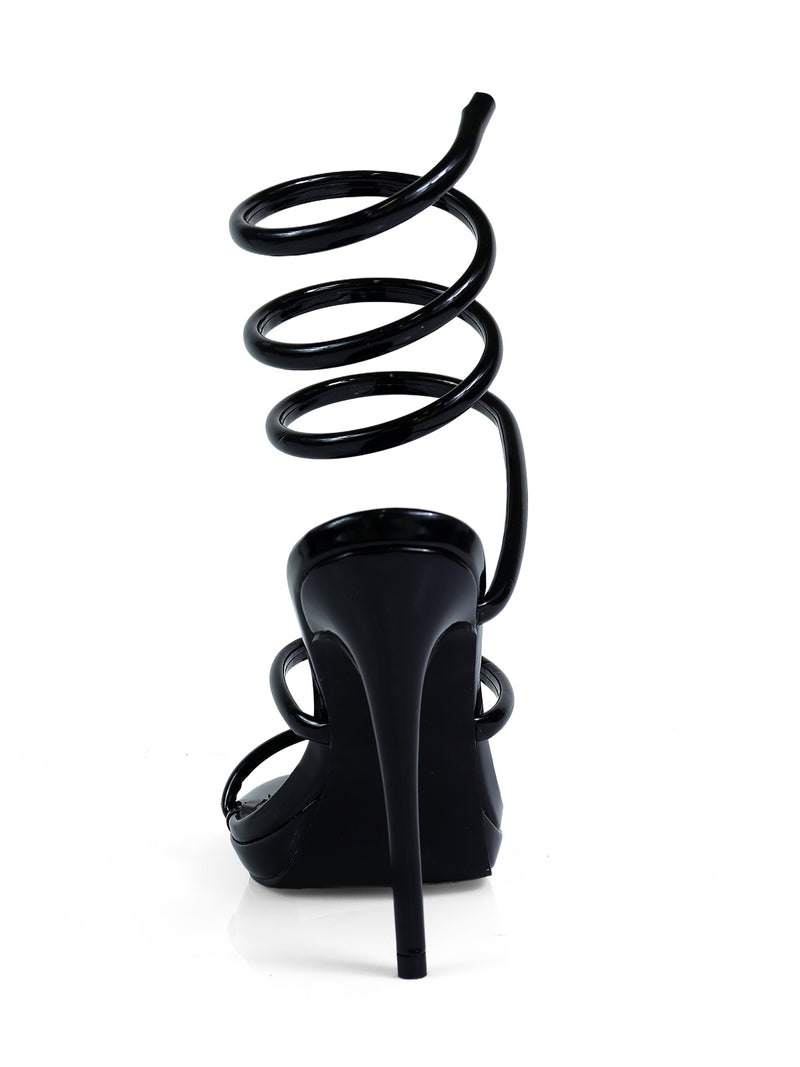 The Sabine Round Toe Heel by Frederick's of Hollywood is a black sandal with a spiral strap wrapping up the ankle, shown from the back on a white background—an elegant pick for any versatile women’s shoe collection.