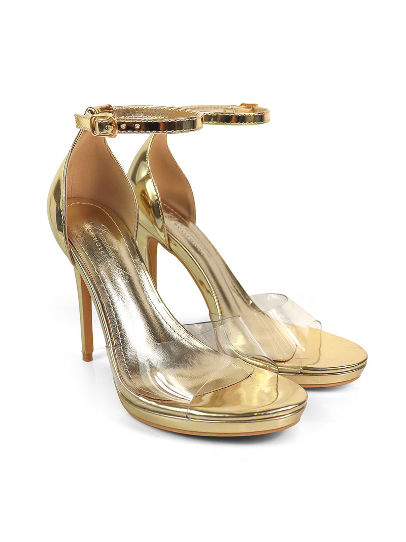 The Stacy Ankle Strap Heels by Frederick's of Hollywood are elegant gold heels with clear plastic toe bands and high heels, showcased against a white background.