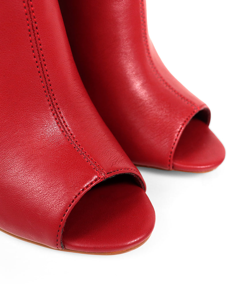 Close-up of Frederick's of Hollywood Yani Folded Ankle Boots, showcasing their red leather, smooth texture, and detailed stitching on the front and sides.