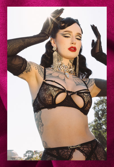 Person wearing black lace lingerie with a blurred outdoor background