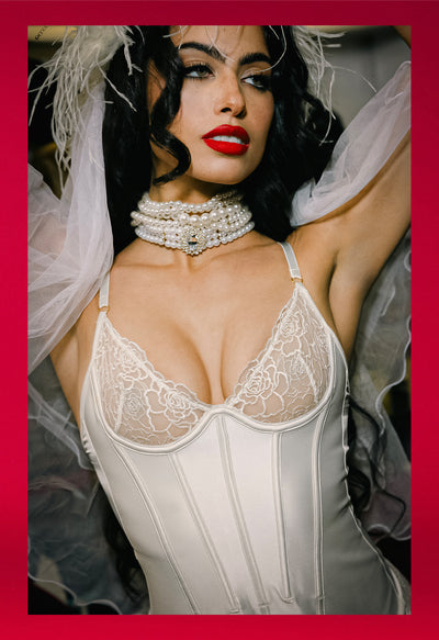 Woman wearing a white lace corset with a red border