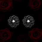 Pair of floral earrings with pearls on a black background with red roses.