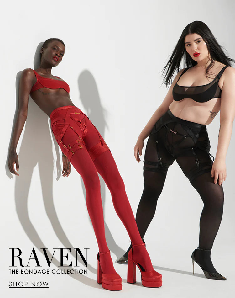 Two women pose against a white background. One wears a red bra, garter belt, stockings, and platform heels. The other wears a black bra, garter belt, stockings, and platform heels. Text reads, RAVEN The Bondage Collection. Shop Now.