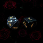 Two dice with sexual innuendos on a dark background with roses