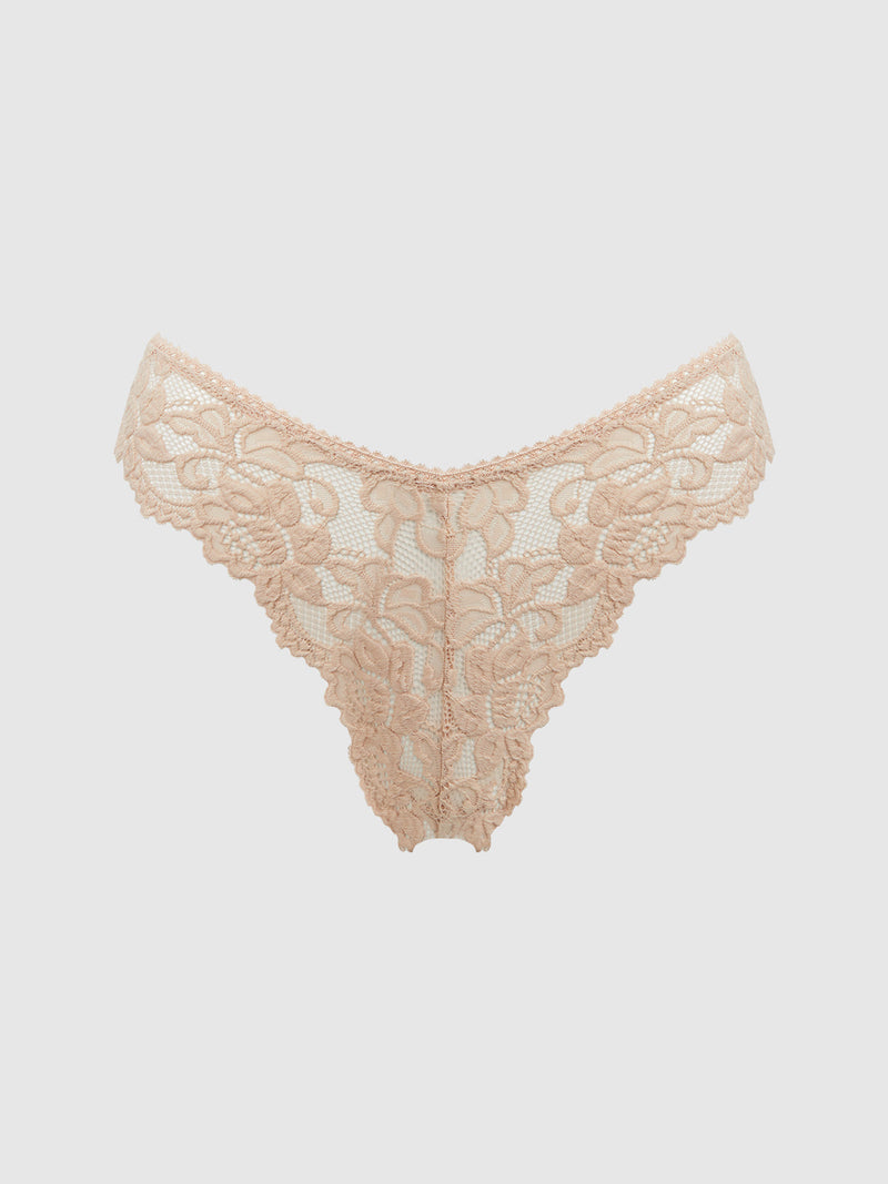 The Jessica Lace Tanga by Frederick's of Hollywood features beige floral lace with minimal coverage and scalloped trim on the waistband and leg openings, shown on a plain light gray background.